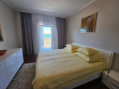 a bedroom with a large bed and a window at Apartments at Villa Stegic in Tisno