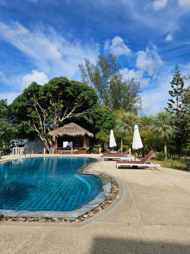 a swimming pool with chairs and umbrellas in a resort at Phangan Utopia Resort in Mae Haad