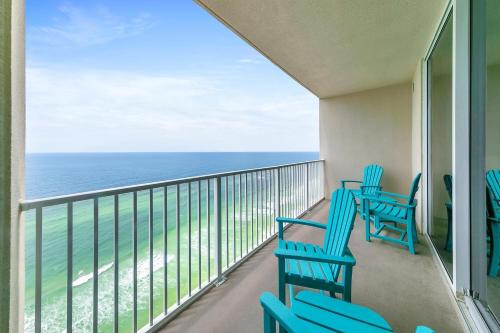 a balcony with blue chairs and the ocean at Tidewater 2308 by Emerald Coast Retreats in Panama City Beach