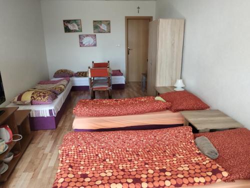 Habitación con 3 camas, mesa y sillas en Apartmany Fantagiro, en Kaluža