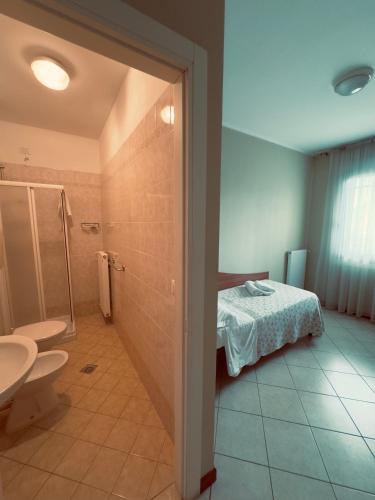 a bathroom with a bed and a shower and a toilet at Albergo Trattoria AL TAJ in Sevegliano