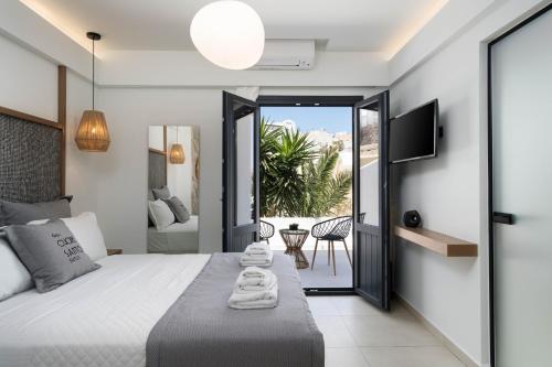 a bedroom with a bed and a view of a patio at CUORE SANTO SUITES in Fira