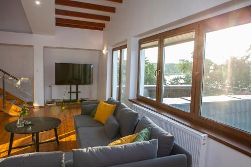 un soggiorno con un divano e una televisione di Apartamenty Jeziorna 40 a Charzykowy