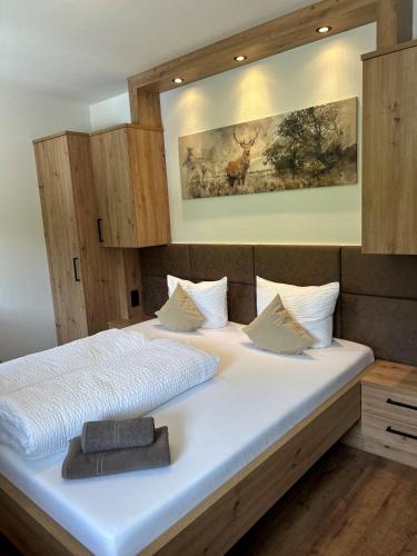 a bedroom with a large white bed with a picture on the wall at Gasthof Steinbichler in Nussdorf am Attersee