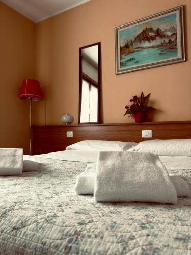 a bedroom with two beds and a mirror on the wall at Albergo Trattoria AL TAJ in Sevegliano