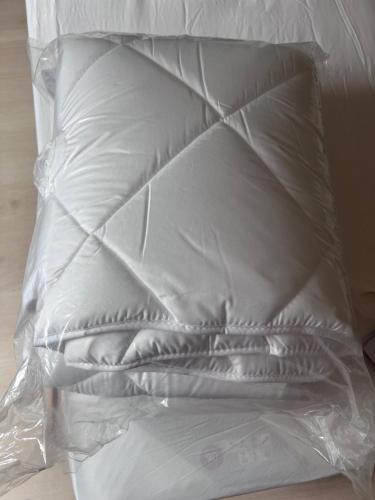 ルマンにあるMaison récente calme 24 heures du Mans 9 couchagesの白い枕がベッドの上に置かれています。