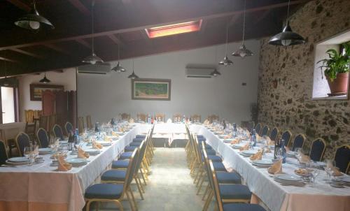 a long table with white tables and chairs in a room at Restaurante y Hostal San Paio in Santiago de Compostela