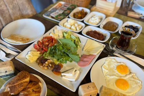 a table with plates of food and eggs and bread at Uçhisar Premium in Nevsehir