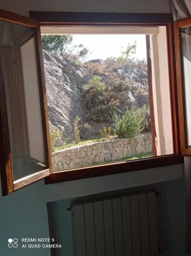 a window in a room with a stone wall at Casa ridente in Arzachena