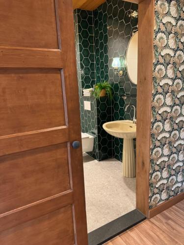 a bathroom with a wooden door and a sink at Vino Grando 't Klooster in Odiliapeel