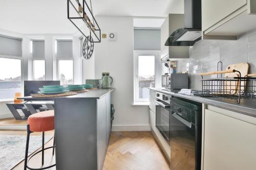 uma cozinha com electrodomésticos de aço inoxidável e um balcão em North Road Luxe New Serviced Apartments- Parking Available with Full Kitchen Amenities em Cardiff