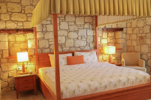1 dormitorio con 1 cama con dosel y 2 lámparas en Alacatı Leylak Hotel, en Alacati