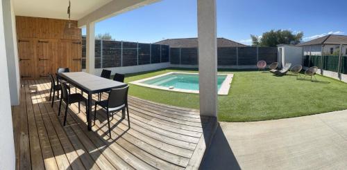 une terrasse avec une table et des chaises ainsi qu'une piscine dans l'établissement Maison de Vacances Avec Piscine Privée en Corse, BORGO, à Borgo