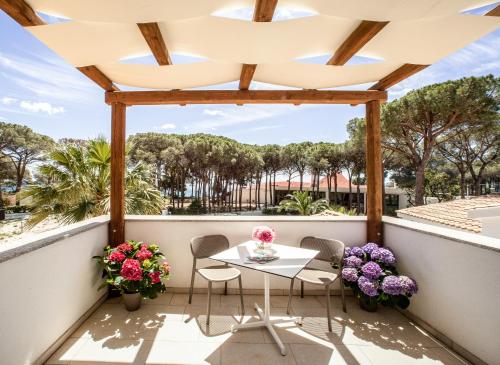 a balcony with a table and chairs and flowers at New Barcavela in Santa Margherita di Pula