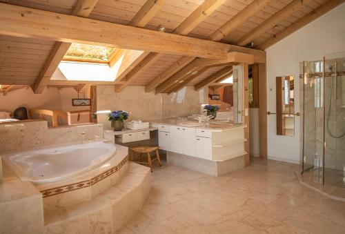 a large bathroom with a tub and a sink at Lakeside Chalet with Panorama View in Thun