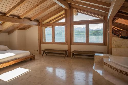 Lakeside Chalet with Panorama View في ثون: غرفة نوم بسرير ونافذة كبيرة