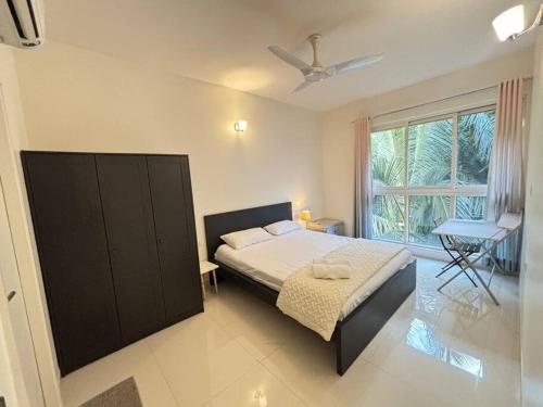 莫尔穆冈Elegant 2 BHK, Pool Front, Zennova Stays的一间带床和大窗户的卧室