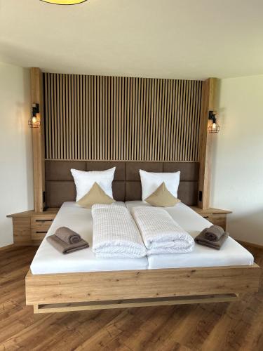 a bedroom with a large bed with white sheets and pillows at Gasthof Steinbichler in Nussdorf am Attersee