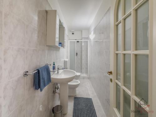 a white bathroom with a sink and a shower at Sea 3 min - Trains 8 - min - Free WiFi - AC in Albisola Superiore