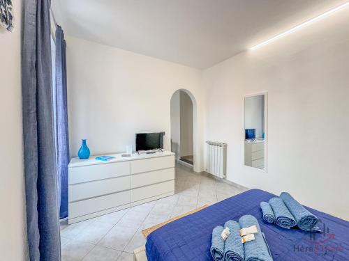 a bedroom with a blue bed and a tv at Sea 3 min - Trains 8 - min - Free WiFi - AC in Albisola Superiore