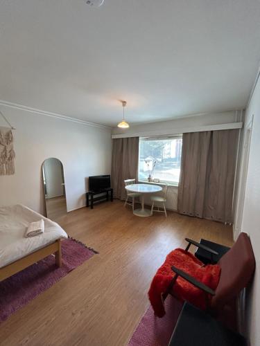 uma sala de estar com uma cama e uma mesa em Studio apartment near the center em Jyväskylä