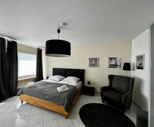 a bedroom with a bed and a chair at Ferienhaus Windmühlenweg mit großem sonnigen Garten -Neu- in Spenge
