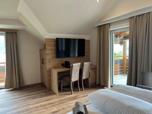 a bedroom with a desk and a television on a wall at Gasthof Steinbichler in Nussdorf am Attersee
