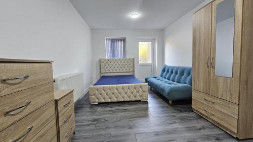 Habitación con cama, silla y sofá en Spacious Double Bedroom with Private Toilet and Shared Kitchen with on premesis parking en Oldbury