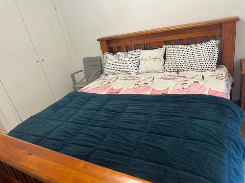a bedroom with a bed with a blue comforter at Home away from Home 22 mins from Airport and CBD in Truganina