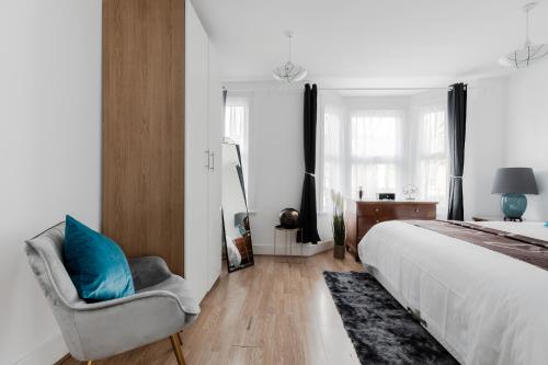 a bedroom with a bed and a blue pillow on a chair at 4 Bed House - Sleeps 6 - Garden Pets Wifi in London