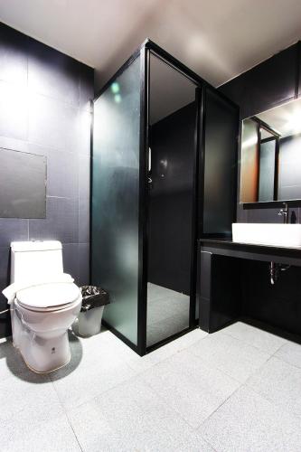 a bathroom with a toilet and a shower and a sink at Coconut budget & Boutique in Hua Hin