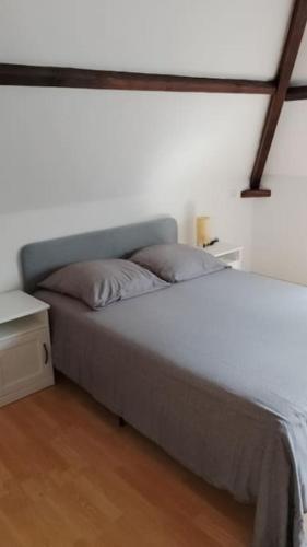 Ce lit se trouve dans un dortoir doté d'un mur blanc. dans l'établissement Gîte à la campagne avec étang de pêche, à Amplier