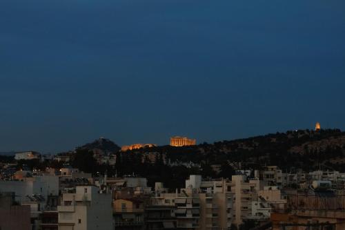 a view of a city at night with the acropolis at The Terrace with Acropolis & Athens view in Athens