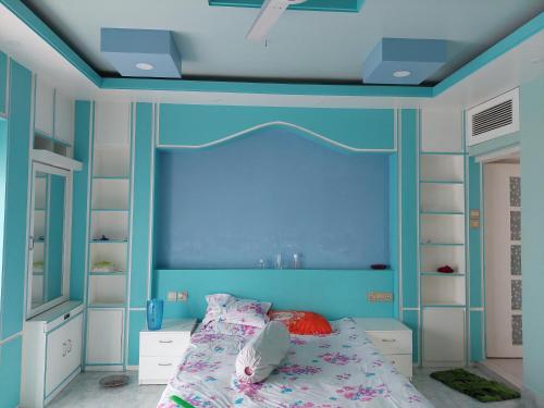 um quarto azul com uma cama e uma parede azul em Rupjan Vila em Muktāgācha