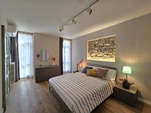 Un dormitorio con una cama y un cuadro en la pared. en La Piazzuola Salo', en Saló