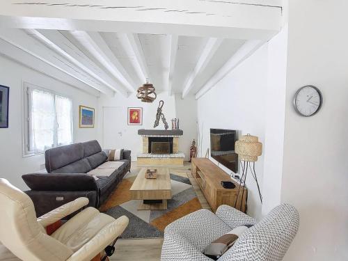 un salon avec un canapé et une cheminée dans l'établissement S-Vacances-Soustons Maison 4 personnes centre-ville avec joli jardin, à Soustons