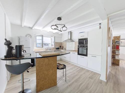 une cuisine avec des armoires blanches et un comptoir noir dans l'établissement S-Vacances-Soustons Maison 4 personnes centre-ville avec joli jardin, à Soustons