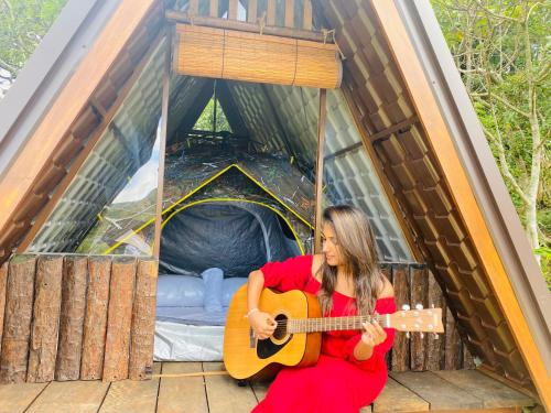 a woman playing a guitar in a tent at Seattle Knuckles in Rangala