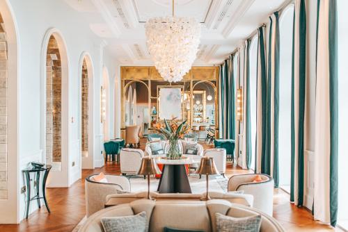 a lobby with a table and chairs and a chandelier at Hilton Imperial Dubrovnik in Dubrovnik
