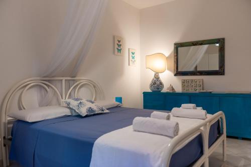 a bedroom with two beds and a mirror at La casa di Daniela- Relax home con veranda in Cala Liberotto