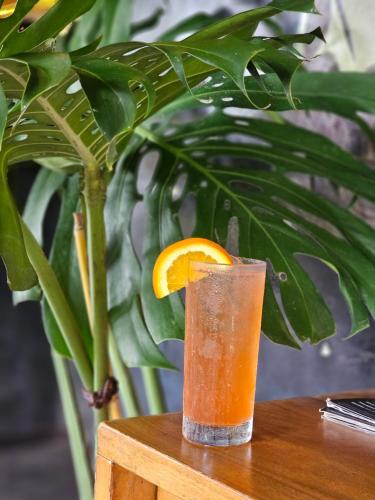 a glass of orange juice sitting on a wooden table at Wasabi in Canggu