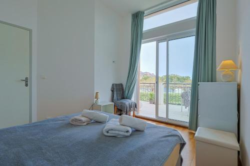 1 dormitorio con cama y ventana grande en Apartment Tiki Plage mit Meerblick und direkt am Strand, en Saint-Raphaël