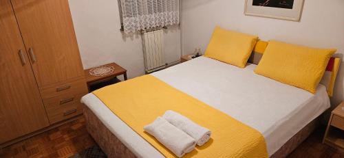 um quarto com uma cama com lençóis amarelos e almofadas amarelas em Apartment LAGUNA 22 em Izola
