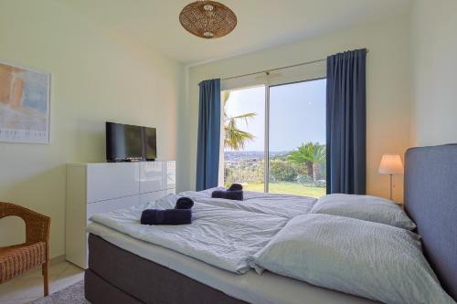 une chambre avec un grand lit avec une grande fenêtre dans l'établissement Provenzalische Villa Maison des Loups - Garten mit Meerblick und Infinity Pool by Riviera HomeLife, à Sainte-Maxime