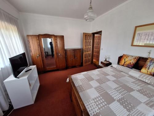 a bedroom with a bed and a flat screen tv at Welcome to Casa Mirao in Póvoa de Lanhoso