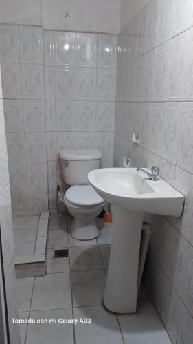 uma casa de banho branca com um WC e um lavatório em Posada de Mary em Sucre