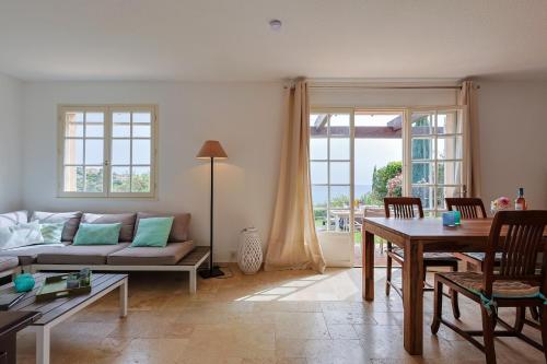 un salon avec un canapé et une table dans l'établissement Provenzalisches Haus Homard - mit privatem Garten und Meerblick by Riviera HomeLife, à Agay