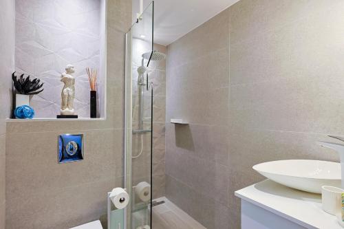 La salle de bains est pourvue d'une douche et d'un lavabo. dans l'établissement Bastidon Les Citronniers für 4 Personen mit Meerblick, à Saint-Raphaël