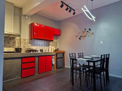 a kitchen with red cabinets and a table with chairs at S & R Homes in Tacloban