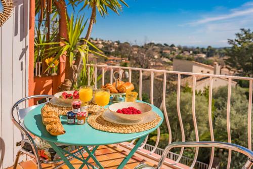 une table avec de la nourriture et des boissons sur un balcon dans l'établissement Le Mimosa, à Vence